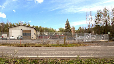 A warehouse property and the yard is protected and demarcated with chain link fencing and a sliding gate.