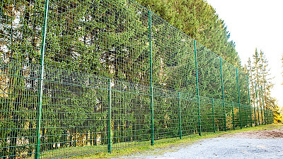 Palloilukentän reunalla on korkea vihreä elementtiaita, joka päälle on asennettu vihreä suojaverkko, jotta pallot eivät karkaa kentän ulkopuolelle.