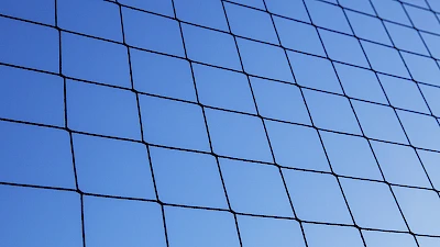 Pallokentälle tarkoitettua suojaverkkoa taivasta vasten.