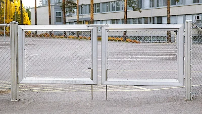 Koulun asfalttipihalle alumiininen, kaksilehtinen huoltoportti, jossa on maasalvat.