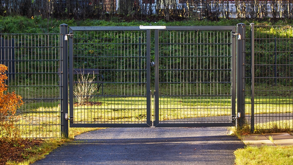 Musta kaksilehtinen saranaportti yhdistettynä mustaan elementtiaitaan.