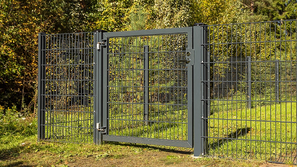 Piha-alue aidattu tummanharmaalla elementtiaidoilla ja siihen on asennettu saranoitu käyntiportti.