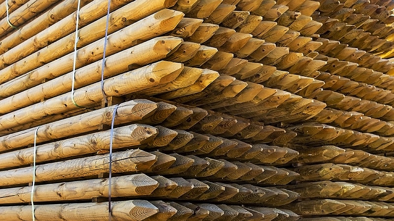 Kestokäsiteltyjä aidan tolppia iso pino.